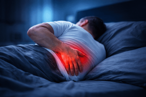 persona con dolor lumbar al despertar en cama